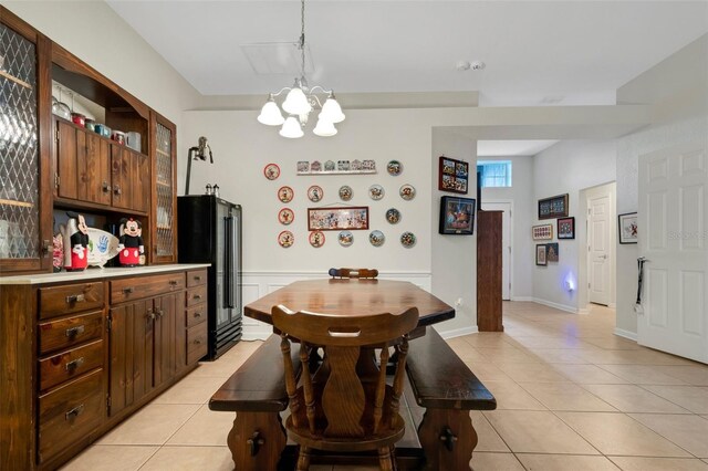 tiled dining room featuring an inviting chandelier