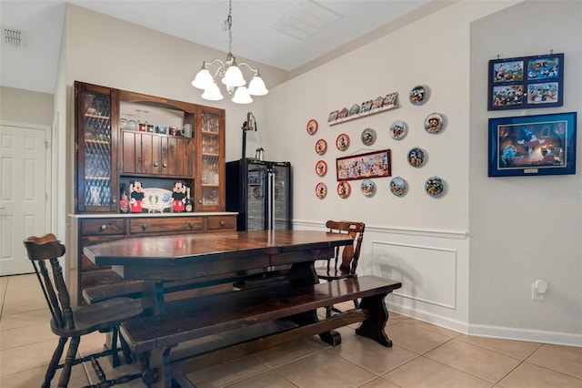 bar featuring pendant lighting, light tile patterned floors, a chandelier, and black fridge