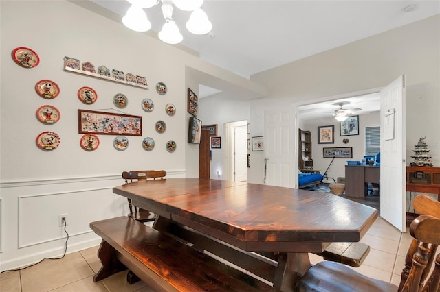 tiled dining area with ceiling fan with notable chandelier