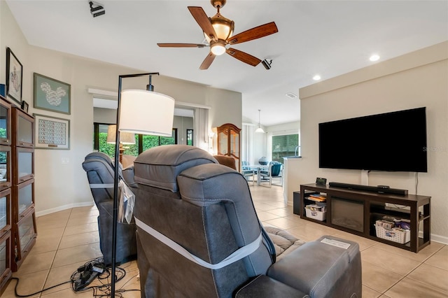 living room with light tile patterned floors, a healthy amount of sunlight, and ceiling fan