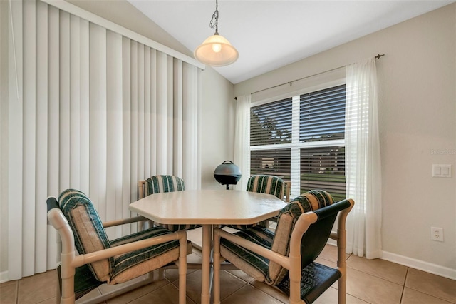 dining space with lofted ceiling and tile patterned flooring