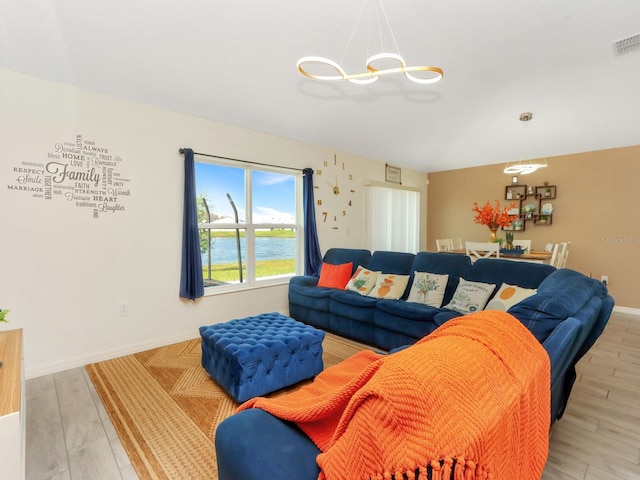 living room featuring light hardwood / wood-style flooring and a water view