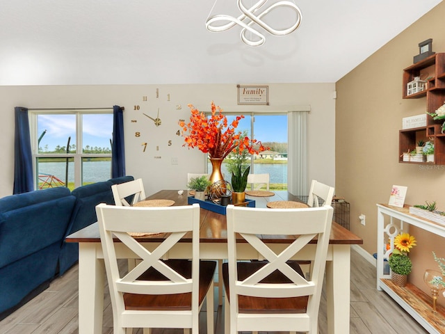 dining space featuring a water view and light hardwood / wood-style flooring