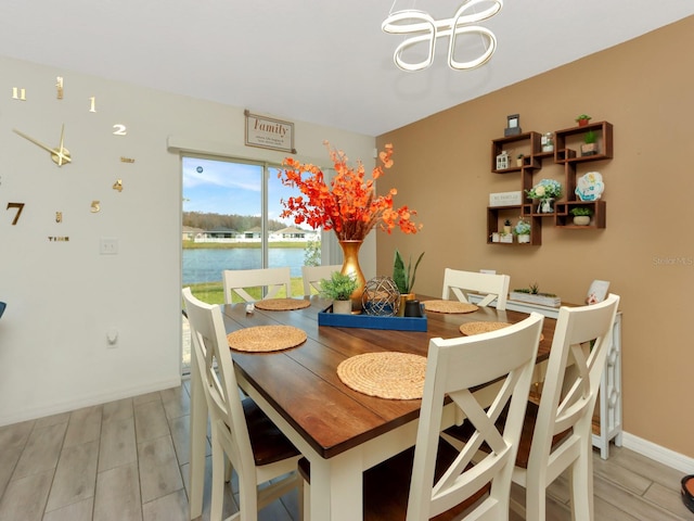 dining room with a water view and light hardwood / wood-style floors