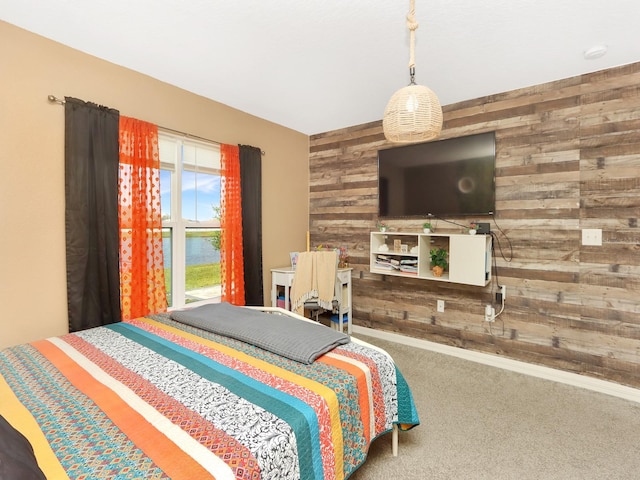 carpeted bedroom featuring wood walls