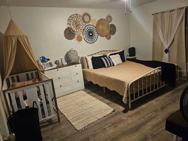 bedroom with vaulted ceiling and dark wood-type flooring