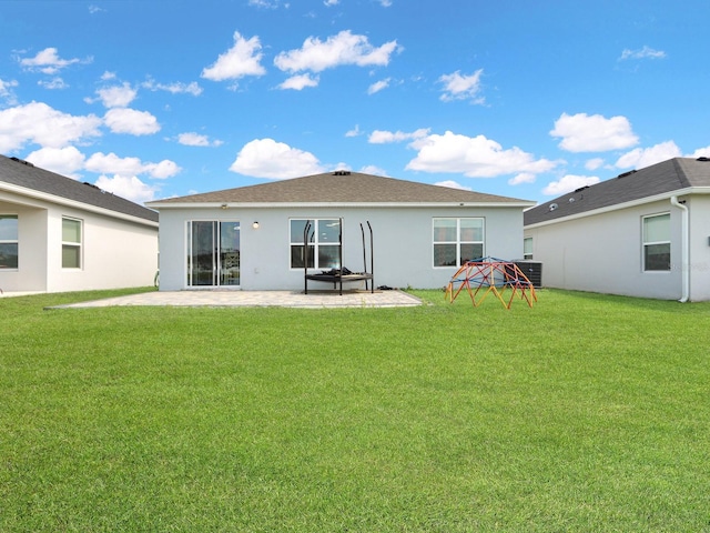 rear view of house with a lawn, cooling unit, and a patio