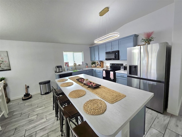 kitchen with blue cabinets, decorative light fixtures, vaulted ceiling, and black appliances