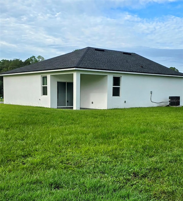 back of house with cooling unit and a yard