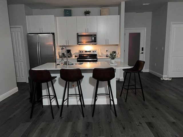 kitchen featuring sink, appliances with stainless steel finishes, an island with sink, and white cabinetry