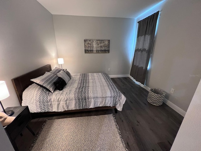 bedroom with dark wood-type flooring