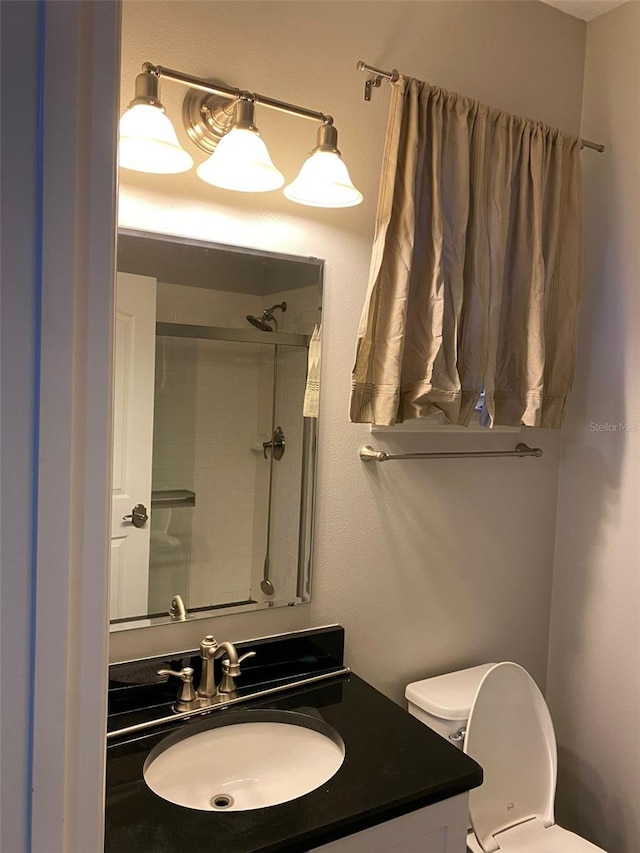 bathroom with vanity, toilet, and walk in shower