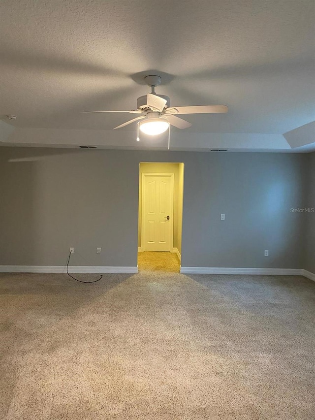 carpeted spare room with ceiling fan and a textured ceiling