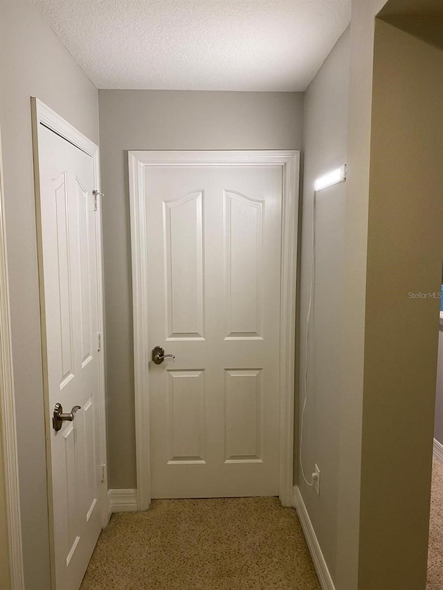 doorway to outside featuring a textured ceiling