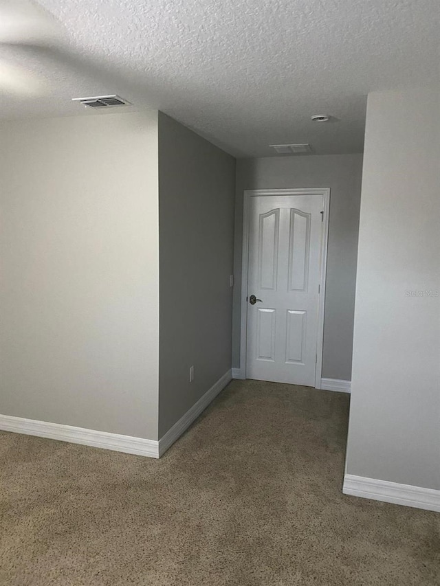 unfurnished room featuring a textured ceiling