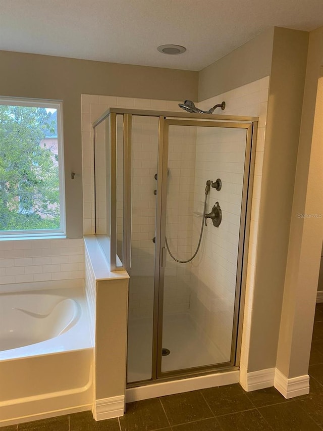 bathroom featuring tile patterned floors and shower with separate bathtub