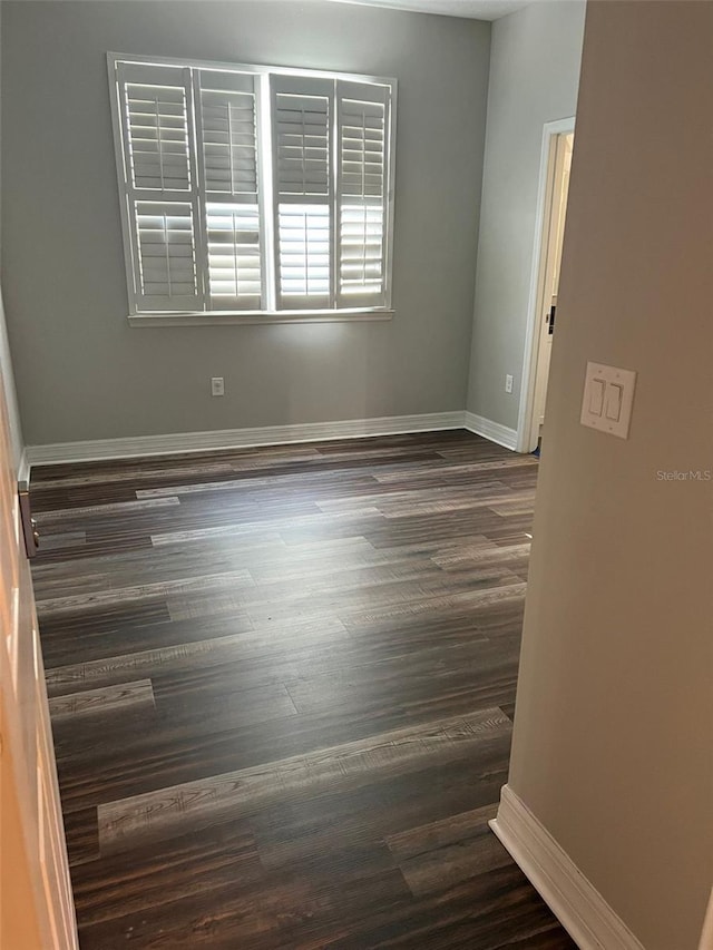 unfurnished room with dark hardwood / wood-style flooring