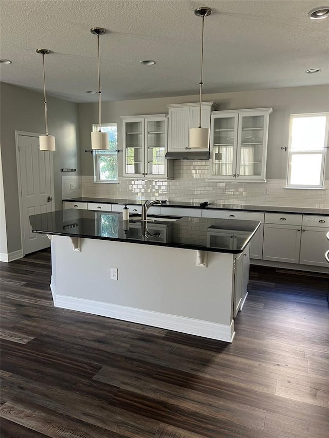 kitchen featuring pendant lighting, a kitchen breakfast bar, and white cabinets