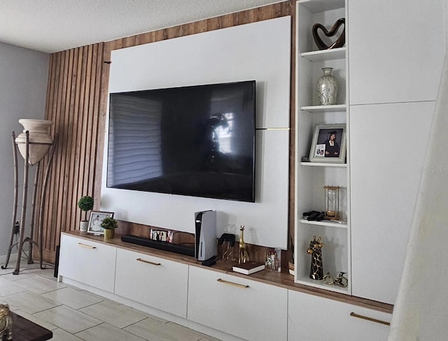 living room with a textured ceiling, built in features, and light tile patterned floors