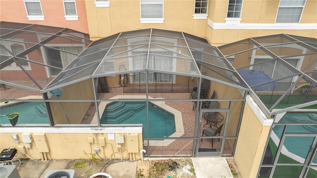 view of swimming pool with central AC unit and glass enclosure