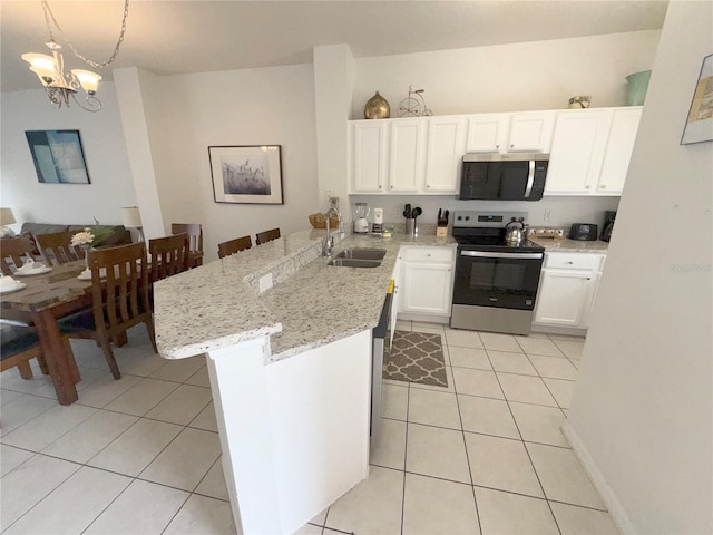 kitchen with light tile patterned flooring, appliances with stainless steel finishes, pendant lighting, sink, and kitchen peninsula