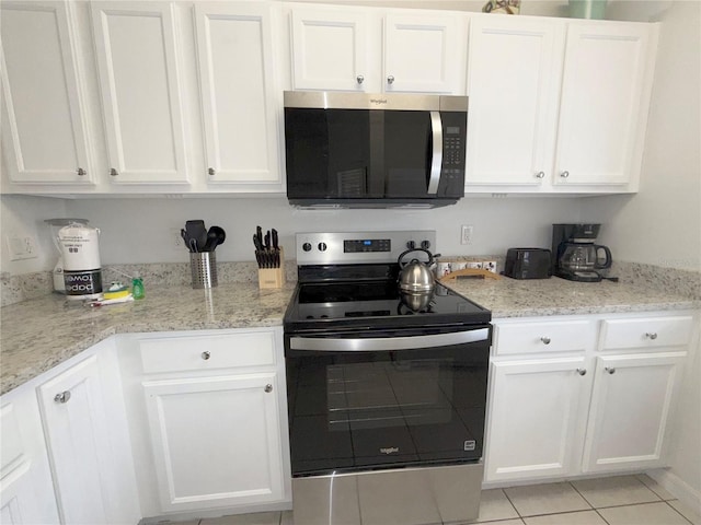 kitchen featuring white cabinetry, light tile patterned floors, light stone counters, and stainless steel appliances