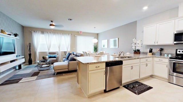 kitchen featuring sink, kitchen peninsula, stainless steel appliances, and light tile patterned floors