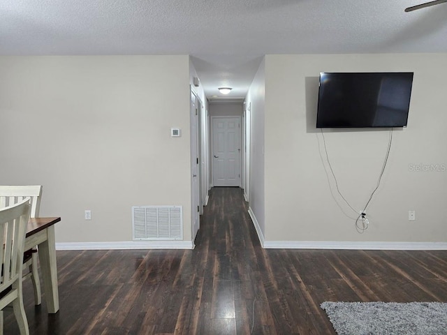 hall with wood-type flooring and a textured ceiling