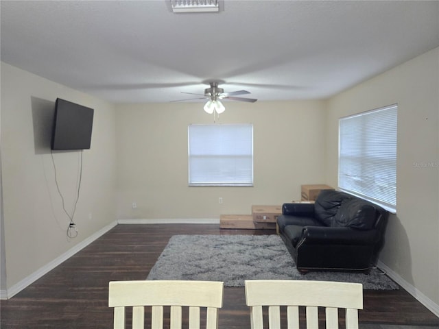 living room with ceiling fan and dark hardwood / wood-style flooring