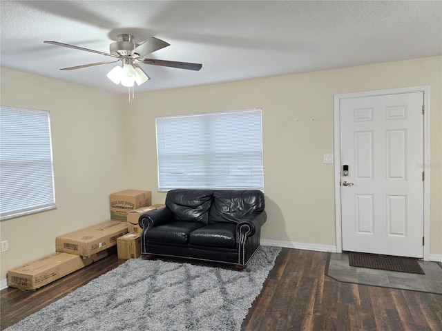 living room with ceiling fan and dark hardwood / wood-style floors