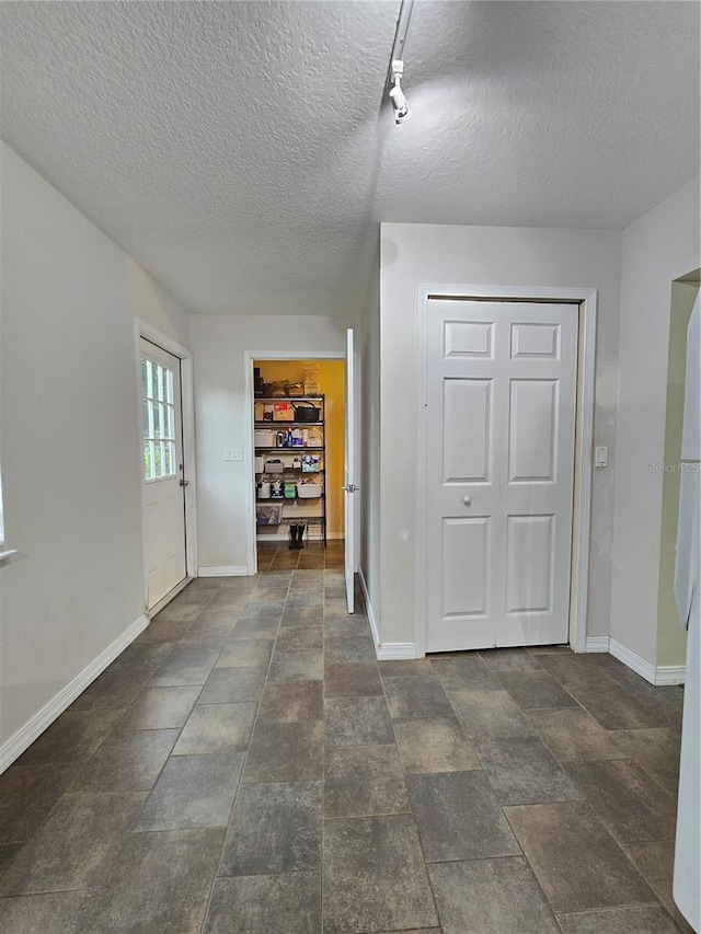 interior space featuring dark tile patterned flooring and a textured ceiling