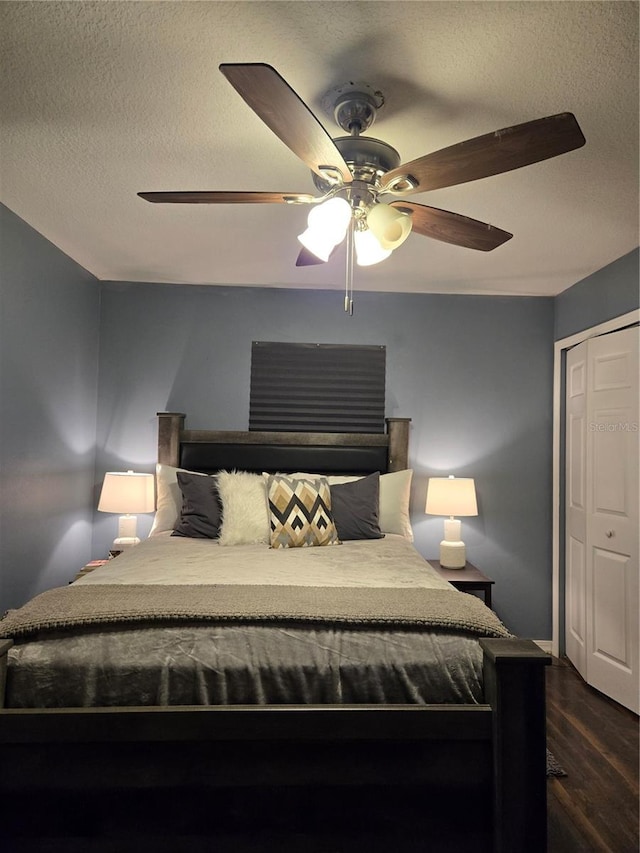 bedroom with ceiling fan, wood-type flooring, a textured ceiling, and a closet