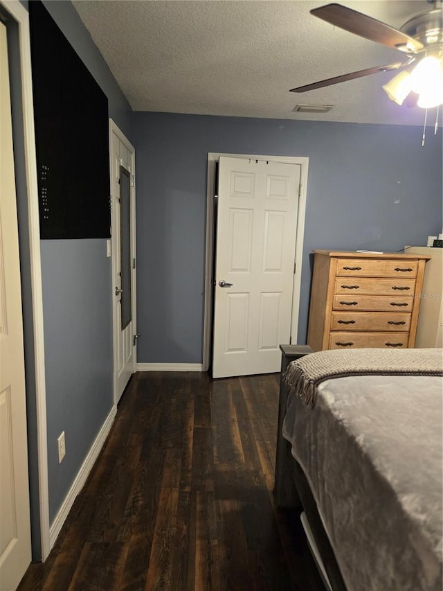 bedroom featuring a textured ceiling, dark hardwood / wood-style floors, and ceiling fan