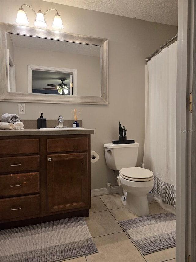 bathroom with a textured ceiling, toilet, tile patterned floors, vanity, and ceiling fan