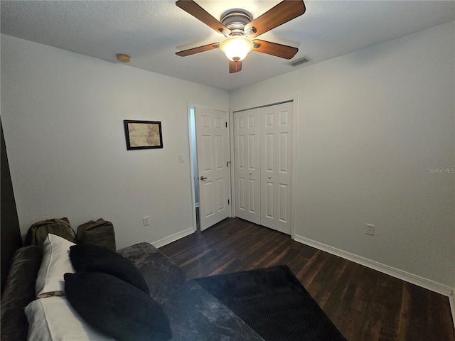 bedroom with a closet, dark hardwood / wood-style flooring, and ceiling fan