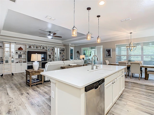 kitchen featuring dishwasher, sink, pendant lighting, an island with sink, and a tray ceiling