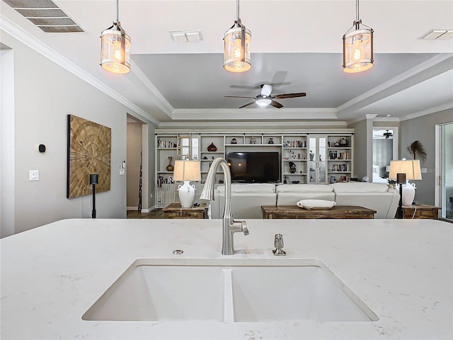 kitchen with sink, decorative light fixtures, ceiling fan, and crown molding