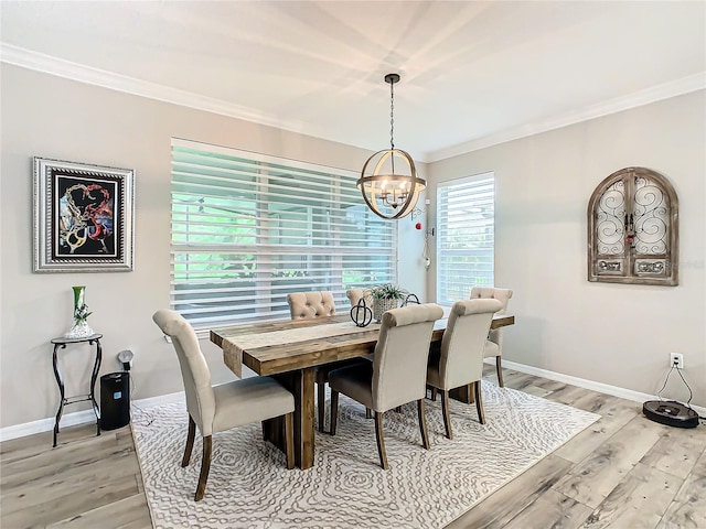 dining area with ornamental molding, a chandelier, and light wood-type flooring