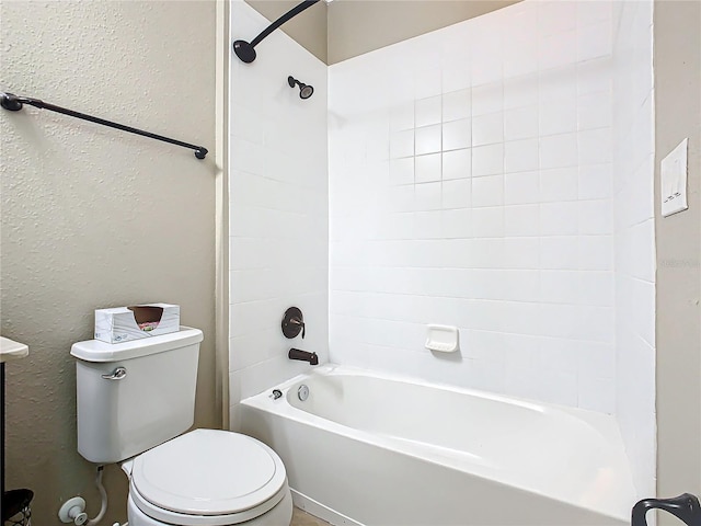 bathroom with toilet and tiled shower / bath combo