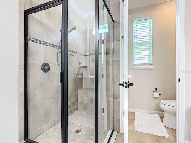 bathroom featuring crown molding, toilet, a shower with shower door, and tile patterned floors