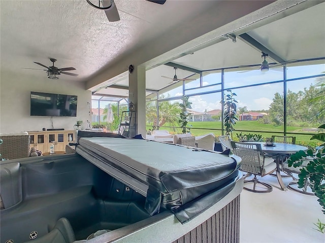 view of patio / terrace with glass enclosure, a hot tub, and ceiling fan