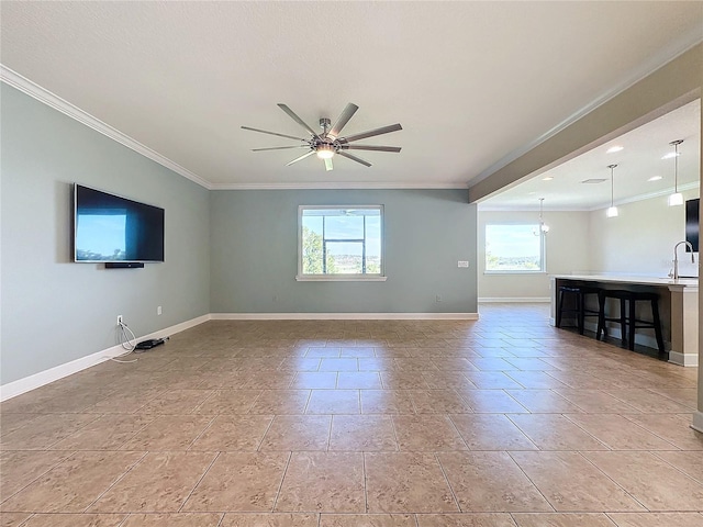 unfurnished living room featuring ceiling fan, sink, and crown molding