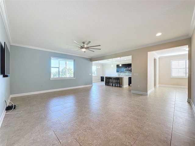 unfurnished living room with ceiling fan, a wealth of natural light, crown molding, and a textured ceiling