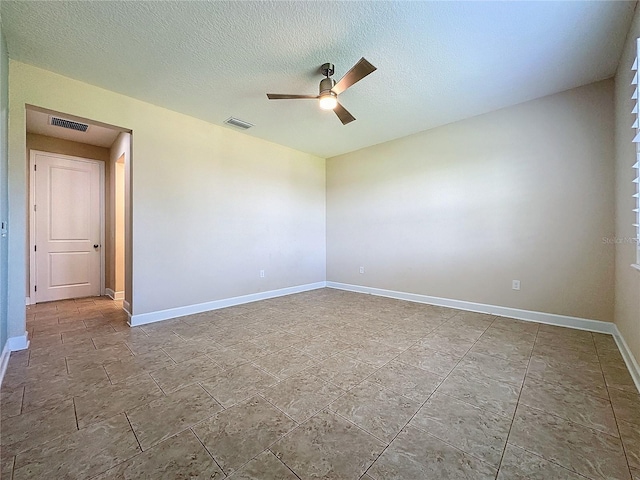 unfurnished room featuring ceiling fan and a textured ceiling