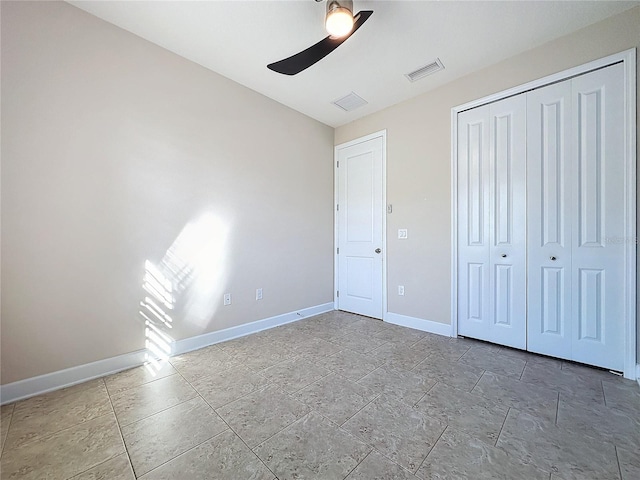 unfurnished bedroom with ceiling fan and a closet