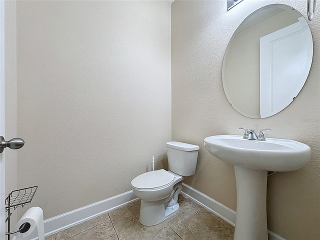 bathroom with toilet and tile patterned flooring