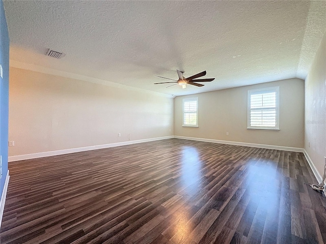 empty room with a textured ceiling, ceiling fan, and dark hardwood / wood-style floors