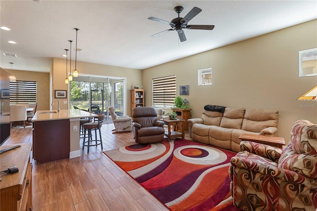 living room with dark hardwood / wood-style flooring, sink, a textured ceiling, and ceiling fan