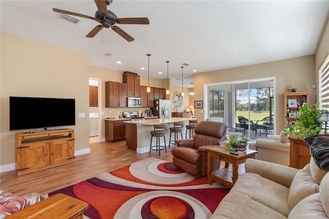 living room with ceiling fan and light wood-type flooring