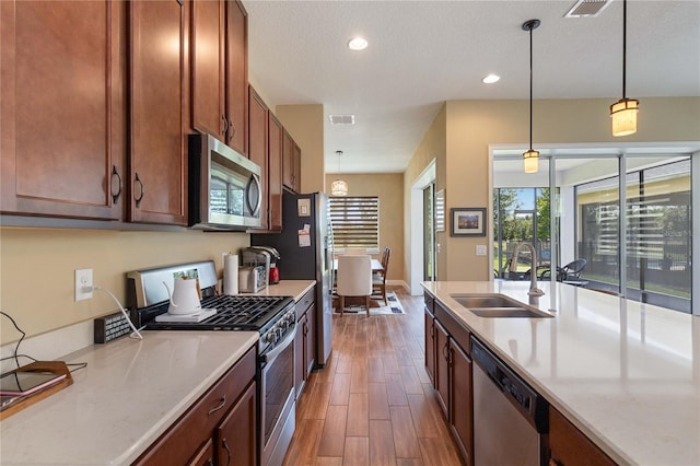 kitchen featuring pendant lighting, sink, plenty of natural light, and appliances with stainless steel finishes